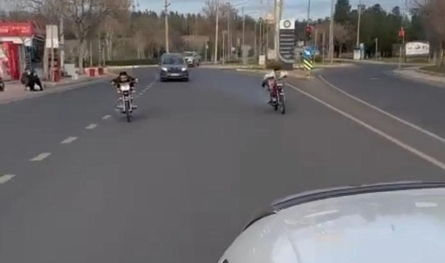 Motosiklet üzerine uzanıp yolculuk eden gençler ölüme davetiye çıkardı