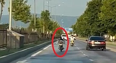 Trafikte tehlikeli yolculuk kameraya yansıdı: Yüzüstü uzanarak motosiklet sürdü