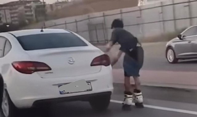 Otomobile tutunarak yolculuk yapan patenli genç canını hiçe saydı: Tehlikeli yolculuk kamerada