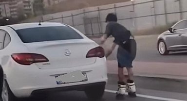 Otomobile tutunarak yolculuk yapan patenli genç canını hiçe saydı: Tehlikeli yolculuk kamerada